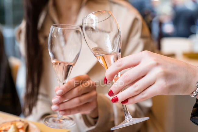 Two women making a celebratory toast in a restaurant — Stock Photo