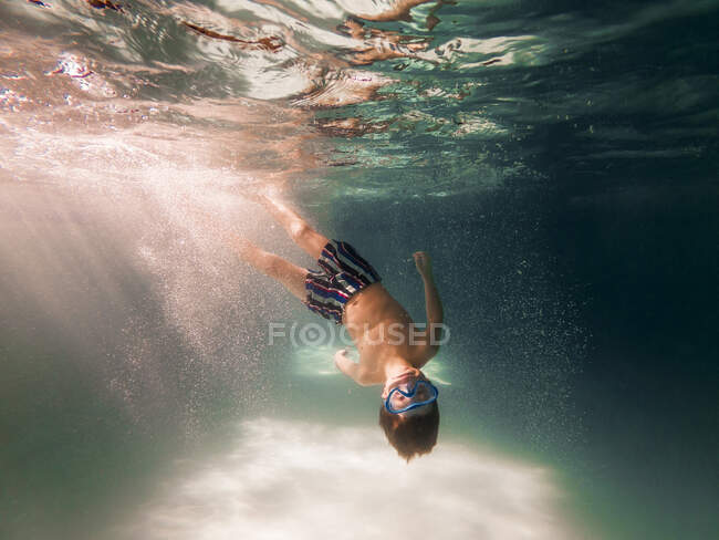 Rapaz mergulhando em uma piscina — Fotografia de Stock