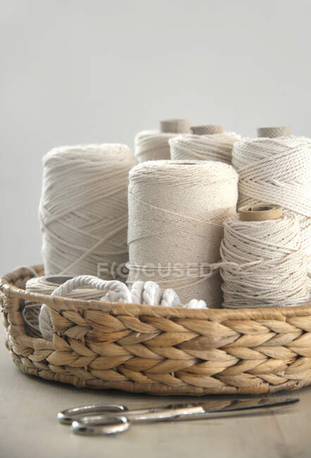 Close-up of macrame yarn in a basket with scissors — Stock Photo