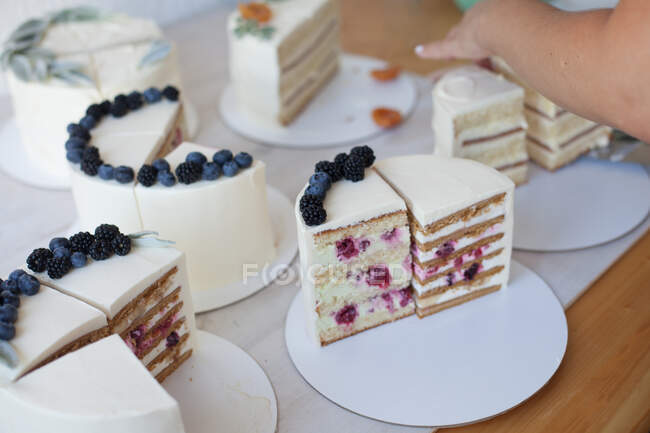 Woman's hand reaching for a slice of cake — Stock Photo