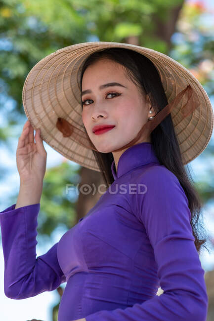 Retrato de una hermosa mujer vestida con un traje tradicional y sombrero cónico, Vietnam - foto de stock