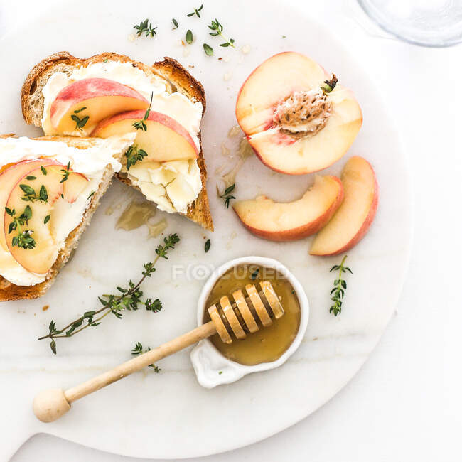 Toasted bread with cream cheese, peaches and honey — Stock Photo