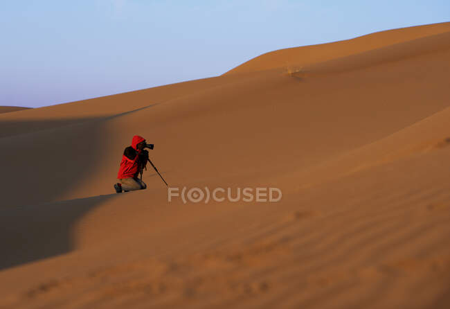 Hombre en el desierto tomando una fotografía, Irán - foto de stock