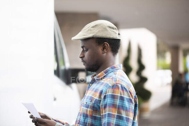 Portrait of a man standing by a truck looking at paperwork — Stock Photo