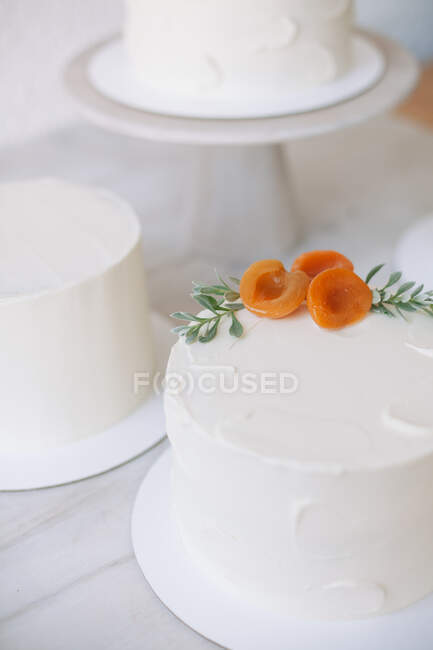 Primo piano di una torta con glassa di crema di burro e decorazione di pesca — Foto stock