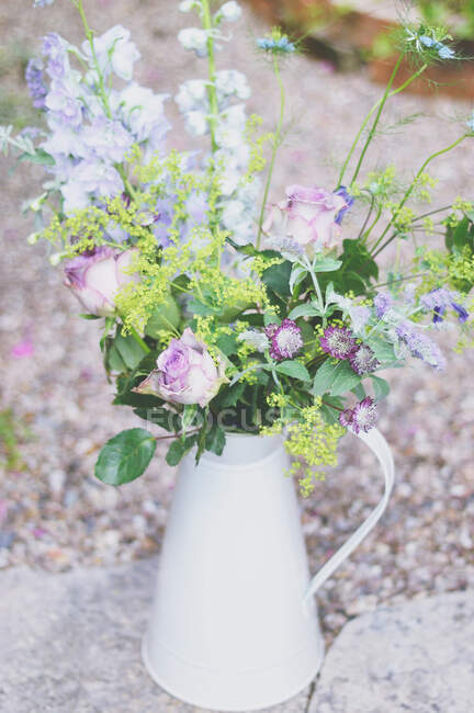 Flower bouquet in a vintage jug — Stock Photo