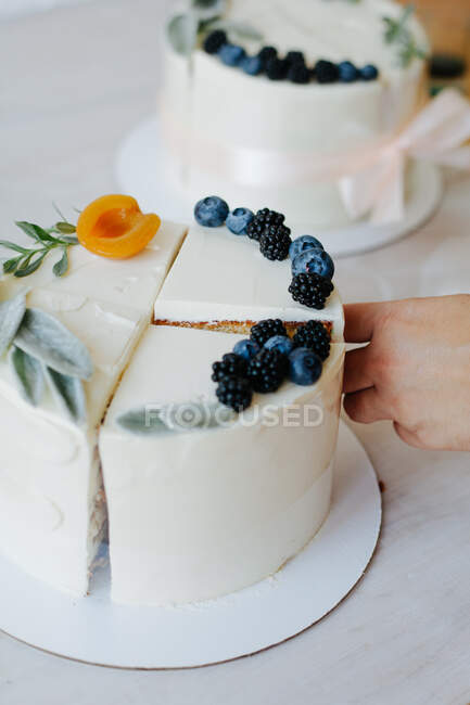 Mulher montando diferentes fatias de bolo para fazer um bolo composto — Fotografia de Stock