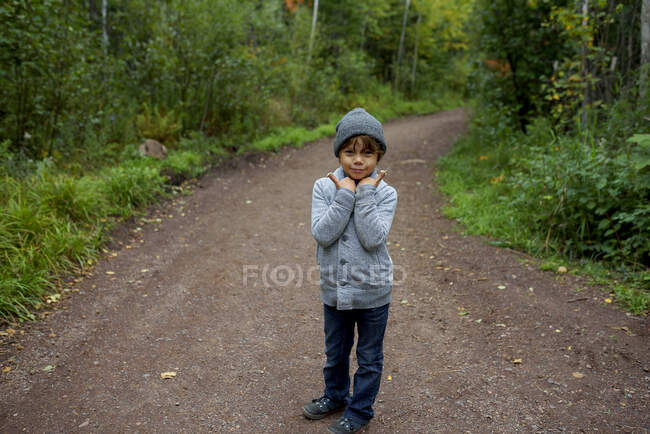 Retrato de un niño de pie en el bosque con setas en los dedos, Estados Unidos - foto de stock