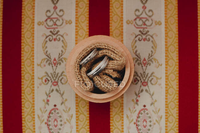 Dois anéis de casamento em uma corda em um pote — Fotografia de Stock