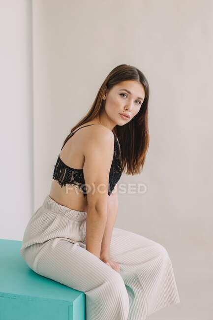 Portrait of a beautiful woman sitting on a table — Stock Photo