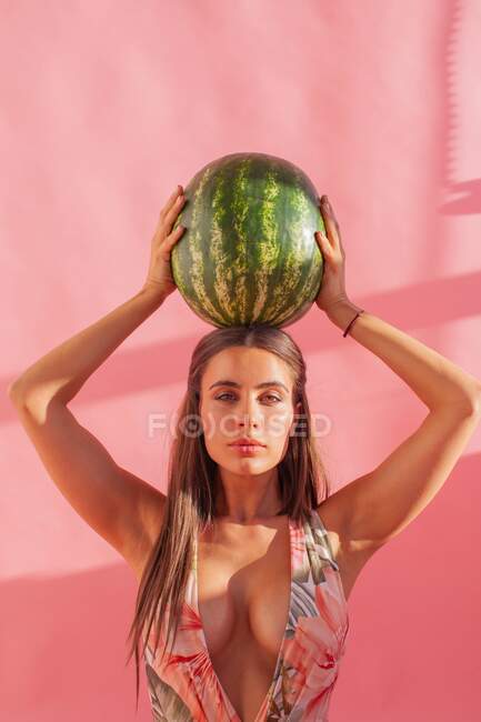 Mulher segurando uma melancia acima da cabeça — Fotografia de Stock