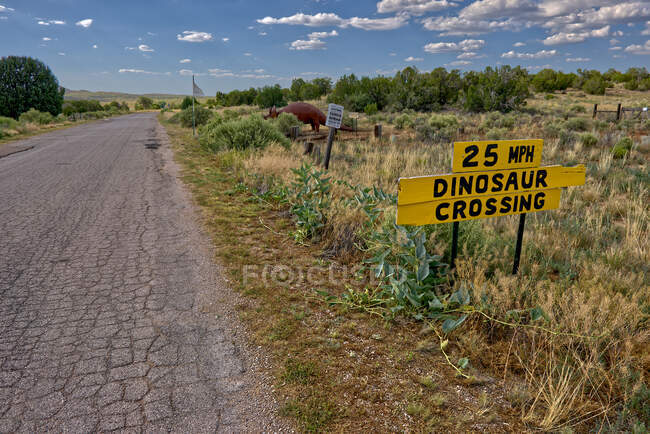 Road sign warning of Dinosaurs at Grand Canyon Caverns, Peach Springs, Mile Marker 115, Arizona, United States — Stock Photo