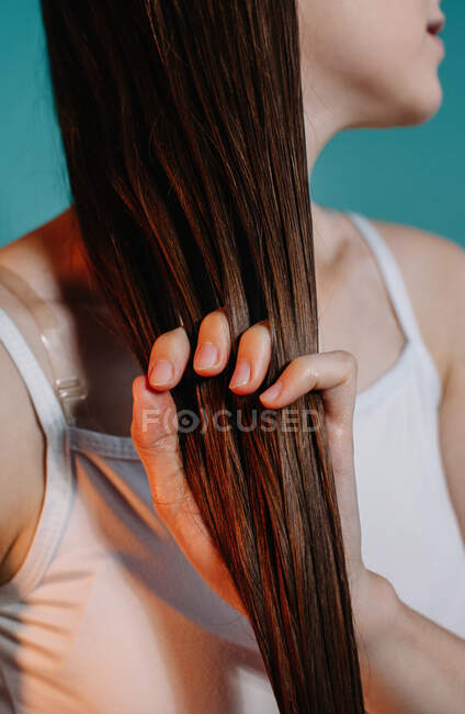 Mujer aplicando aceite a su cabello - foto de stock