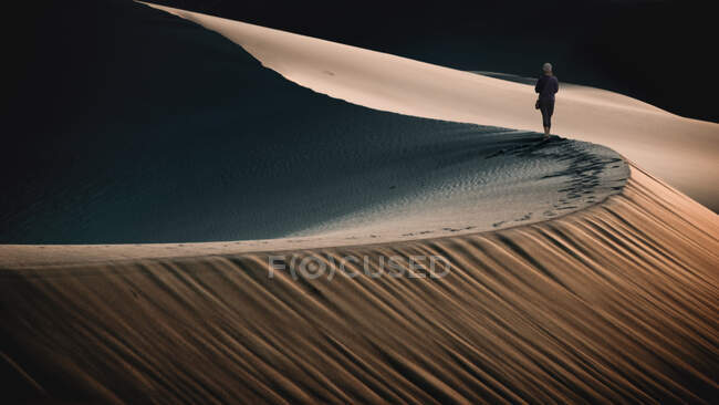 Donna che cammina lungo il crinale di una duna di sabbia nel deserto, Stati slegati — Foto stock