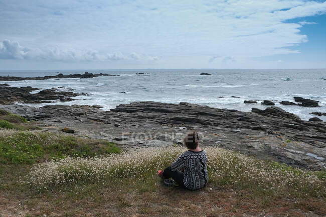 Mujer sentada en la playa, Quiberon, Bretaña, Francia - foto de stock