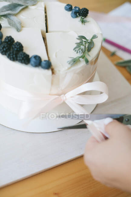 Woman tying together four slices of cake to make a compound cake — Stock Photo