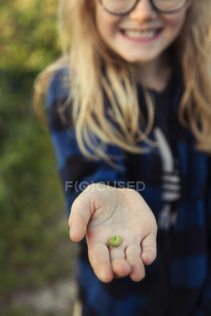 Sonriente niño sosteniendo una oruga, Dinamarca - foto de stock