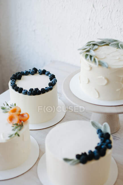 Selection of cakes with buttercream icing and fruit — Stock Photo