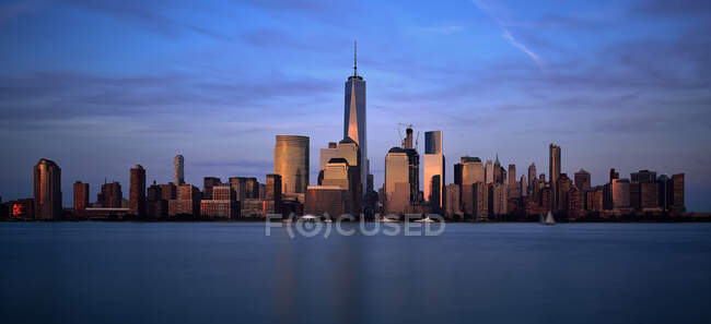 City skyline of One World Trade Center and Battery Park city esplanade at atardecer, Manhattan, Nueva York, Estados Unidos - foto de stock
