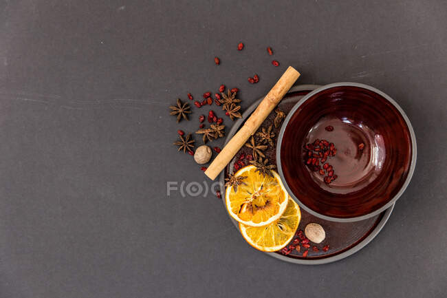Palito de canela, anis estrelado e fatias de laranja em um prato — Fotografia de Stock