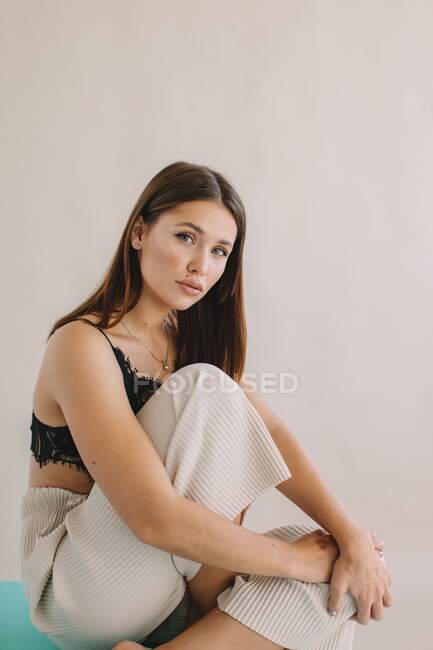 Portrait of a beautiful woman sitting on a table — Stock Photo