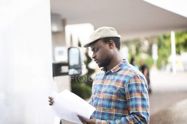 Portrait of a man standing by a truck looking at paperwork — Stock Photo