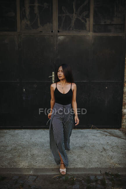 Стильна азіатська жінка, що йде на вулиці — стокове фото