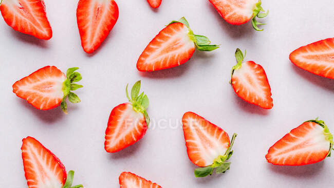 Halbierte Erdbeeren auf rosa Hintergrund — Stockfoto