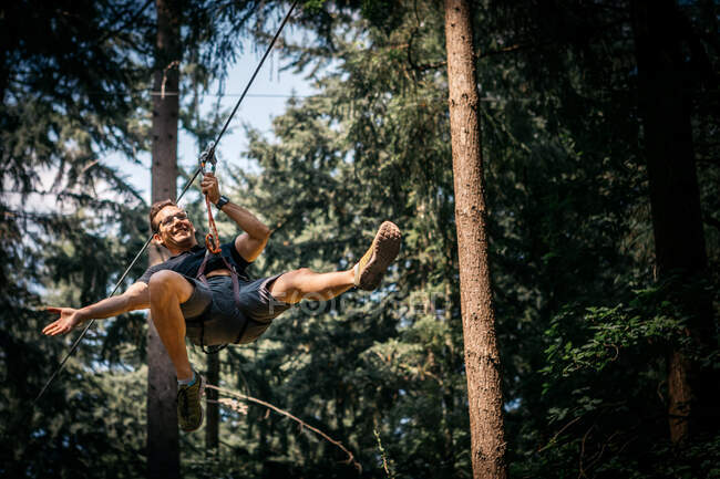 Smiling man on a zip line — Foto stock
