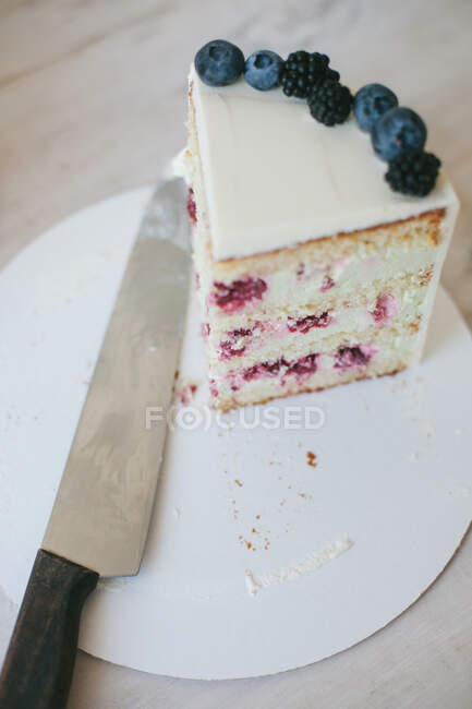 Fatia de bolo de framboesa e creme de queijo ao lado de uma faca — Fotografia de Stock