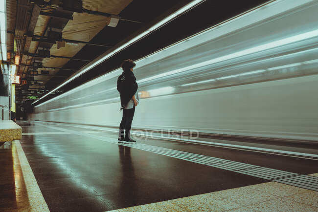 Frau steht in der U-Bahn, als ein Zug vorbeifährt, Spanien — Stockfoto