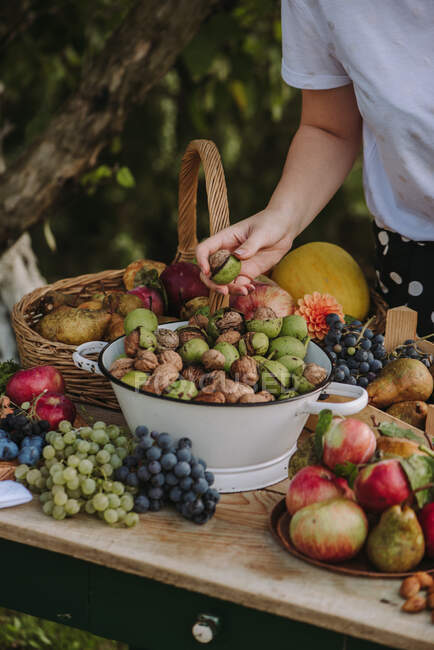 Imagem cortada de mulher e mesa com frutas e nozes — Fotografia de Stock
