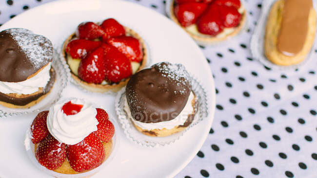French choux pastries and strawberry tarts — Stock Photo