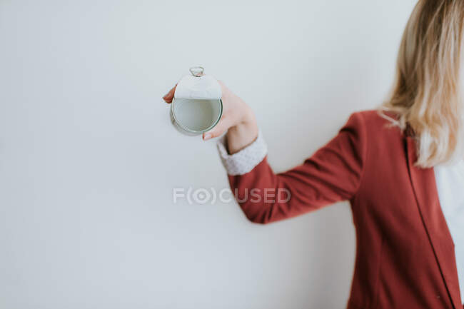 Mulher segurando lata de metal vazio no fundo branco — Fotografia de Stock