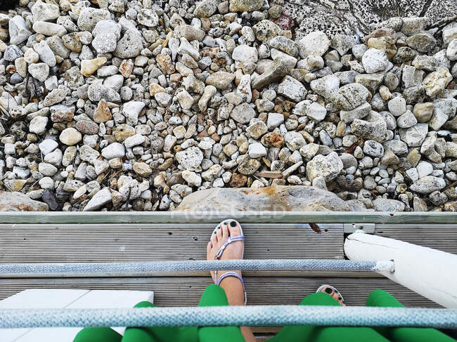 Vista aérea del pie de una mujer de pie en un muelle, Italia - foto de stock