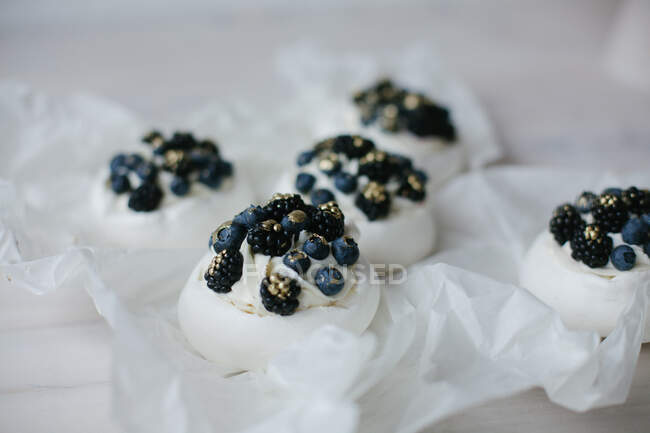 Pavlova-Desserts mit Blaubeeren und Brombeeren auf Pergament — Stockfoto