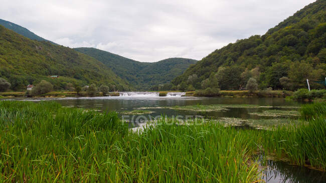 Río que atraviesa un paisaje rural, Bosnia y Herzegovina - foto de stock