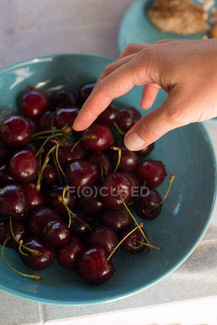 Woman reaching for a cherry — Stock Photo