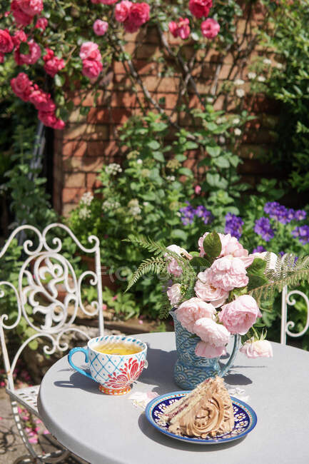 Tè e torta in un giardino di rose inglesi in estate, Inghilterra, Regno Unito — Foto stock