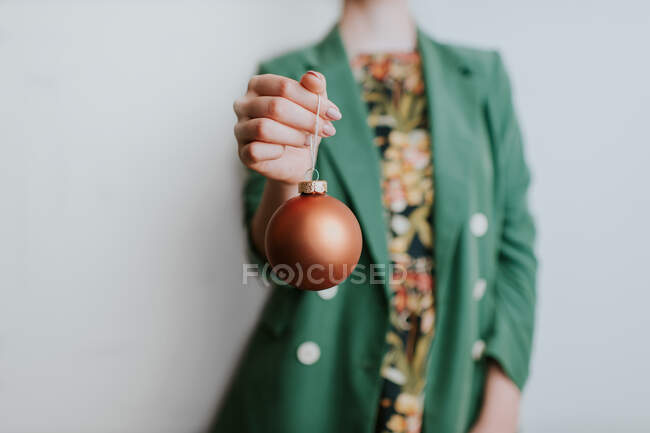 Woman in green jacket holding christmas bauble — Stock Photo