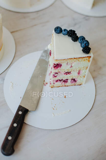 Tranche de gâteau aux framboises et au fromage à la crème à côté d'un couteau — Photo de stock
