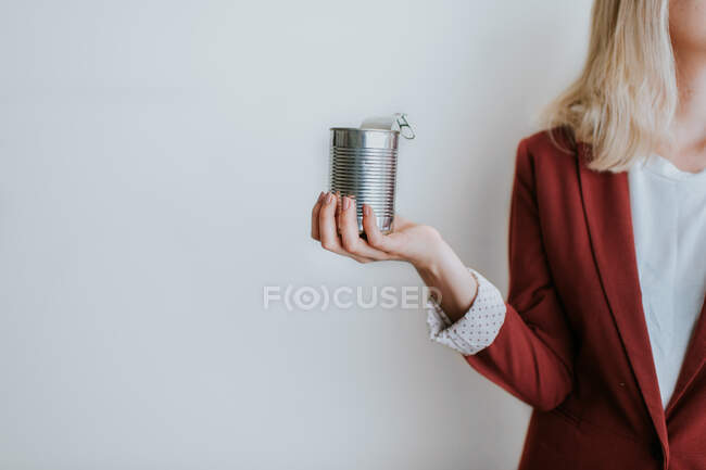 Жінка тримає металеву банку на білому тлі — стокове фото