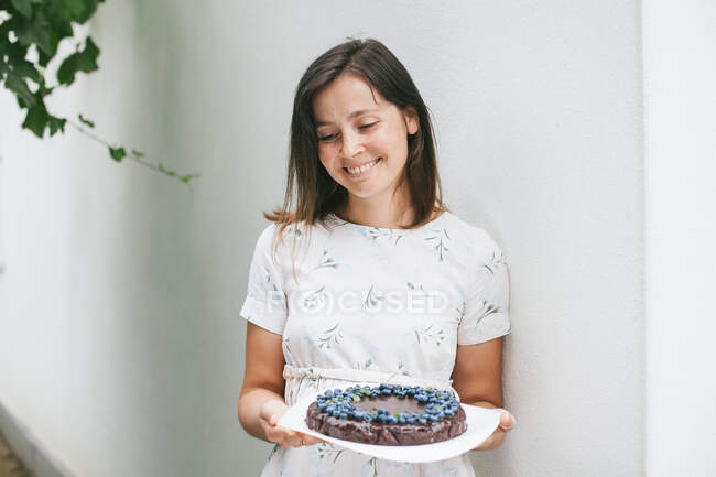 Femme tenant un gâteau brownie au chocolat aux myrtilles — Photo de stock