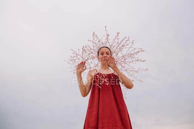 Donna in piedi nel deserto con un fiore davanti al viso, Russia — Foto stock