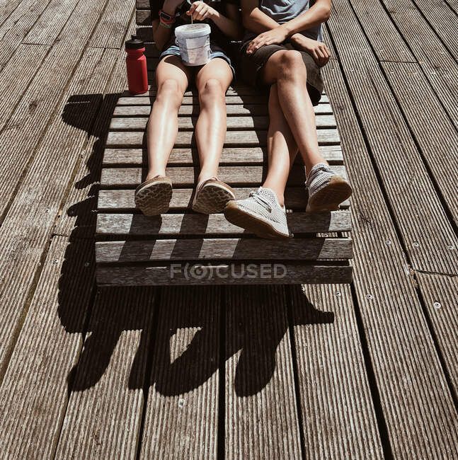 Мальчик и девочка сидят на шезлонге на террасе, Дания — стоковое фото