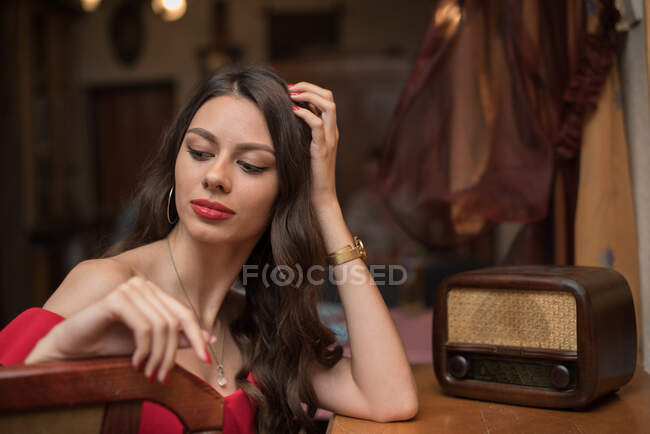 Retrato de uma mulher elegante sentada ao lado de um rádio — Fotografia de Stock