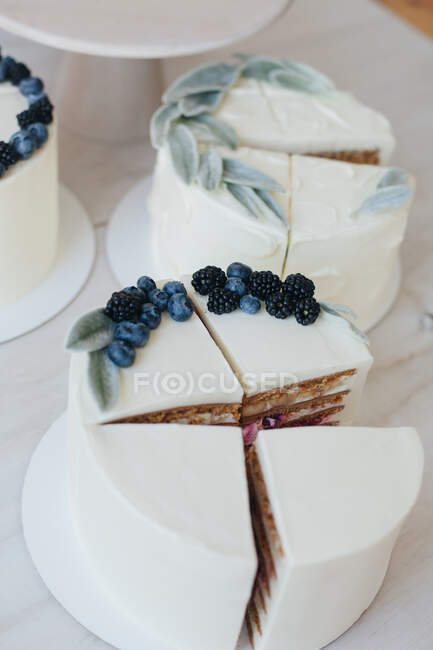 Fatias de bolo com cobertura de creme de manteiga e frutas — Fotografia de Stock