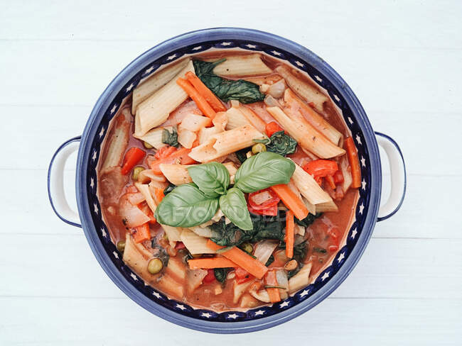 Bowl of vegetarian pasta with peppers, carrots and basil — Stock Photo