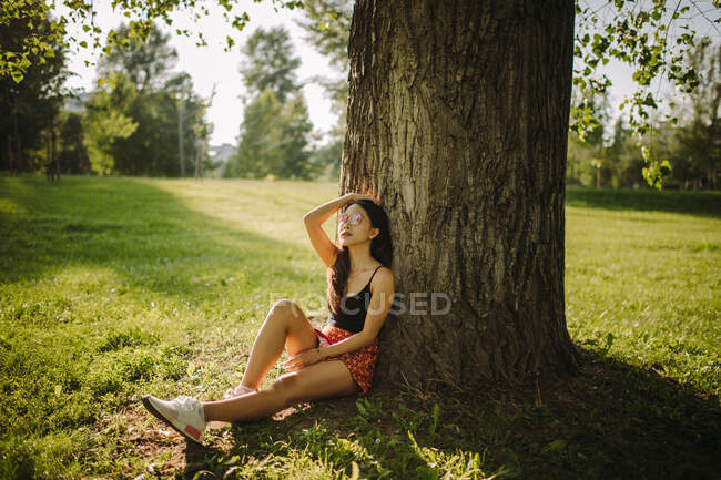 Frau sitzt unter einem Baum im Park, Serbien — Stockfoto