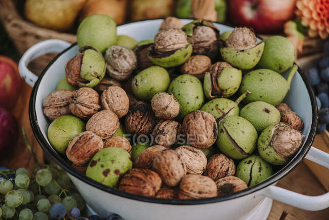 Орехи в миске на столе, полном осенних продуктов — стоковое фото